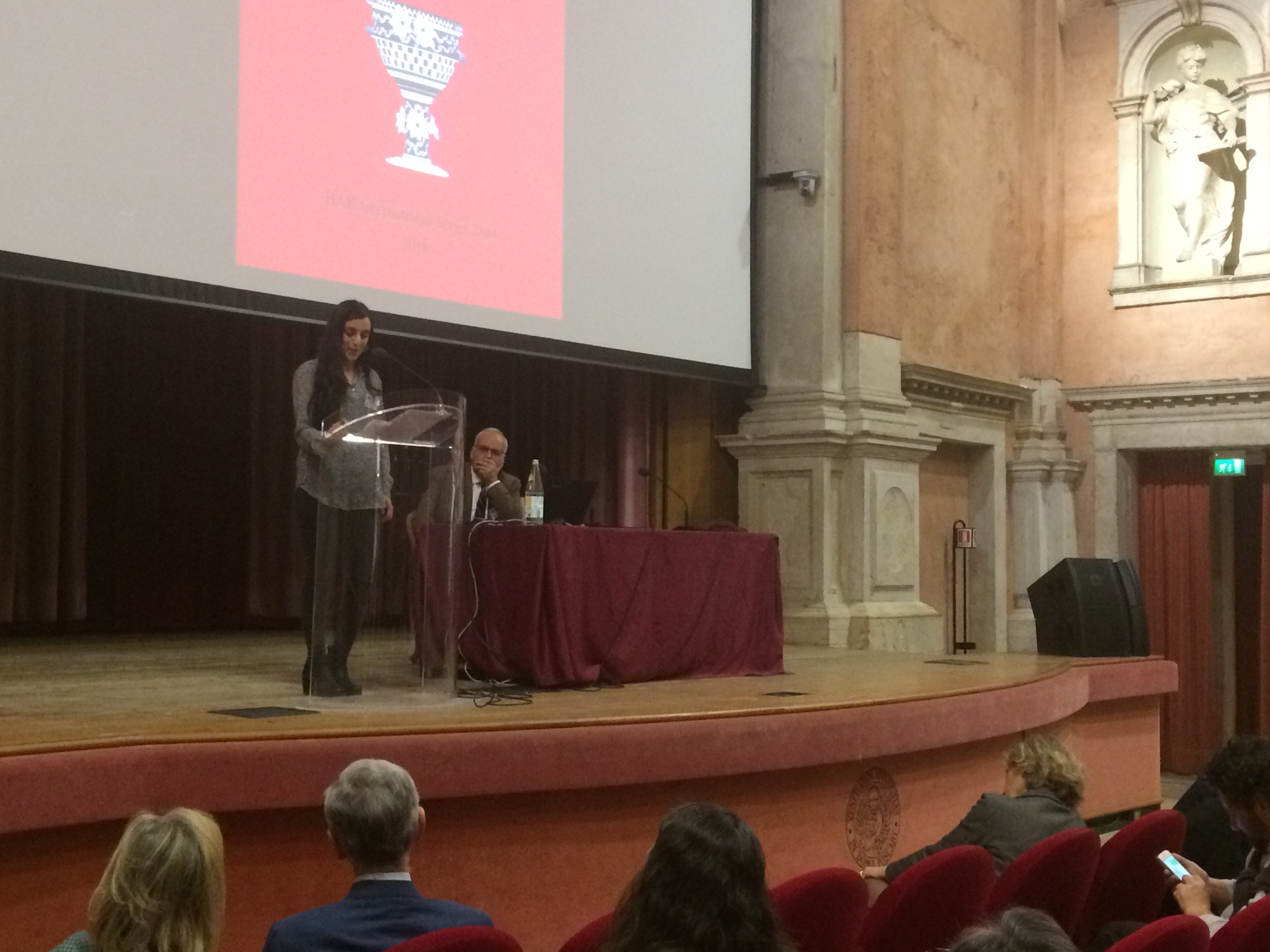 Giorgia Baldacci is reading a message on behalf of the volume editors